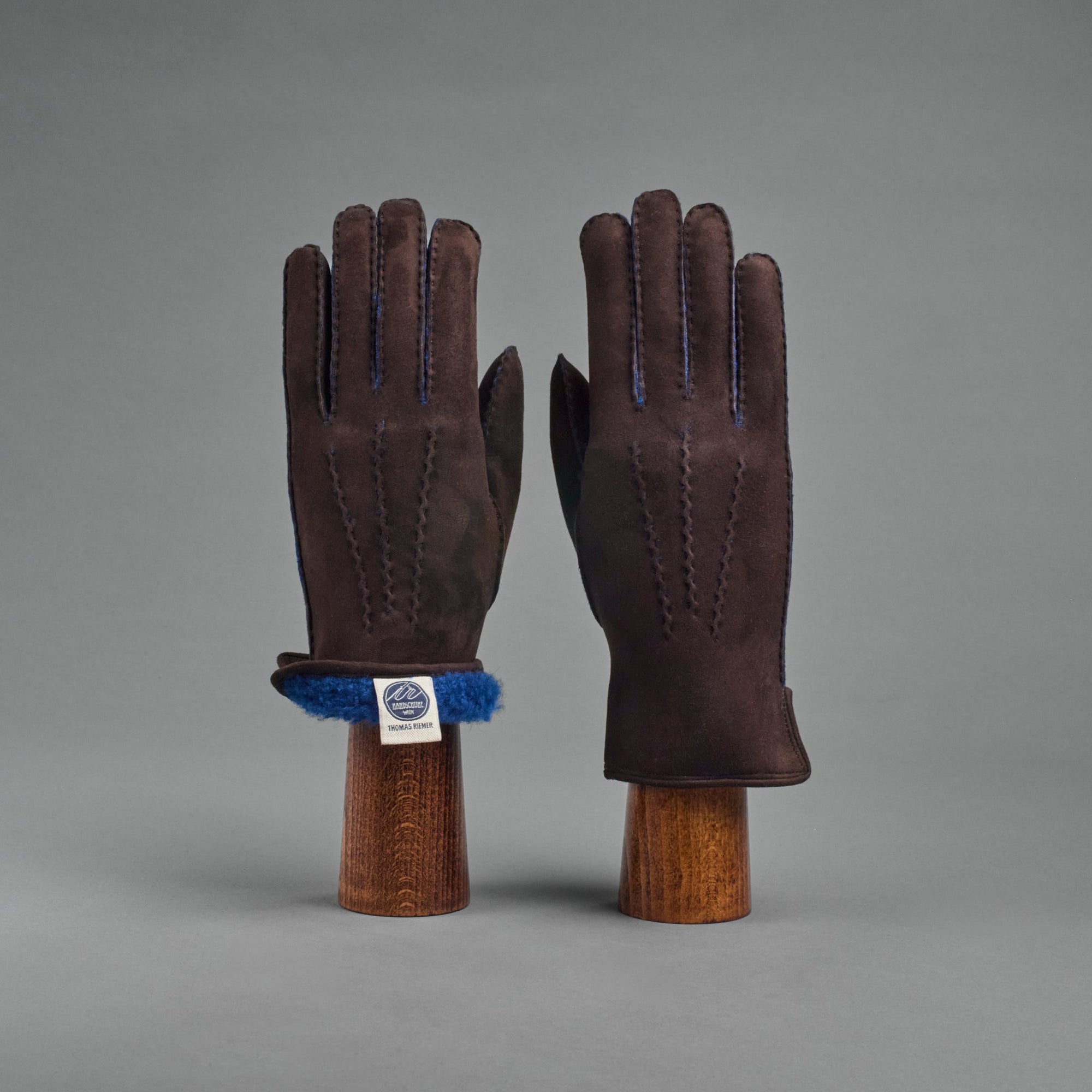 Damenhandschuhe aus dunkelbraunem gelocktem Lammfell, gefüttert mit blauem Lammfell