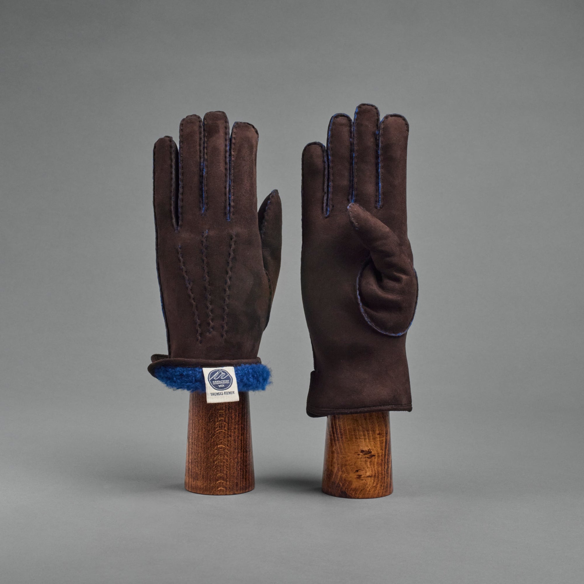 Damenhandschuhe aus dunkelbraunem gelocktem Lammfell, gefüttert mit blauem Lammfell