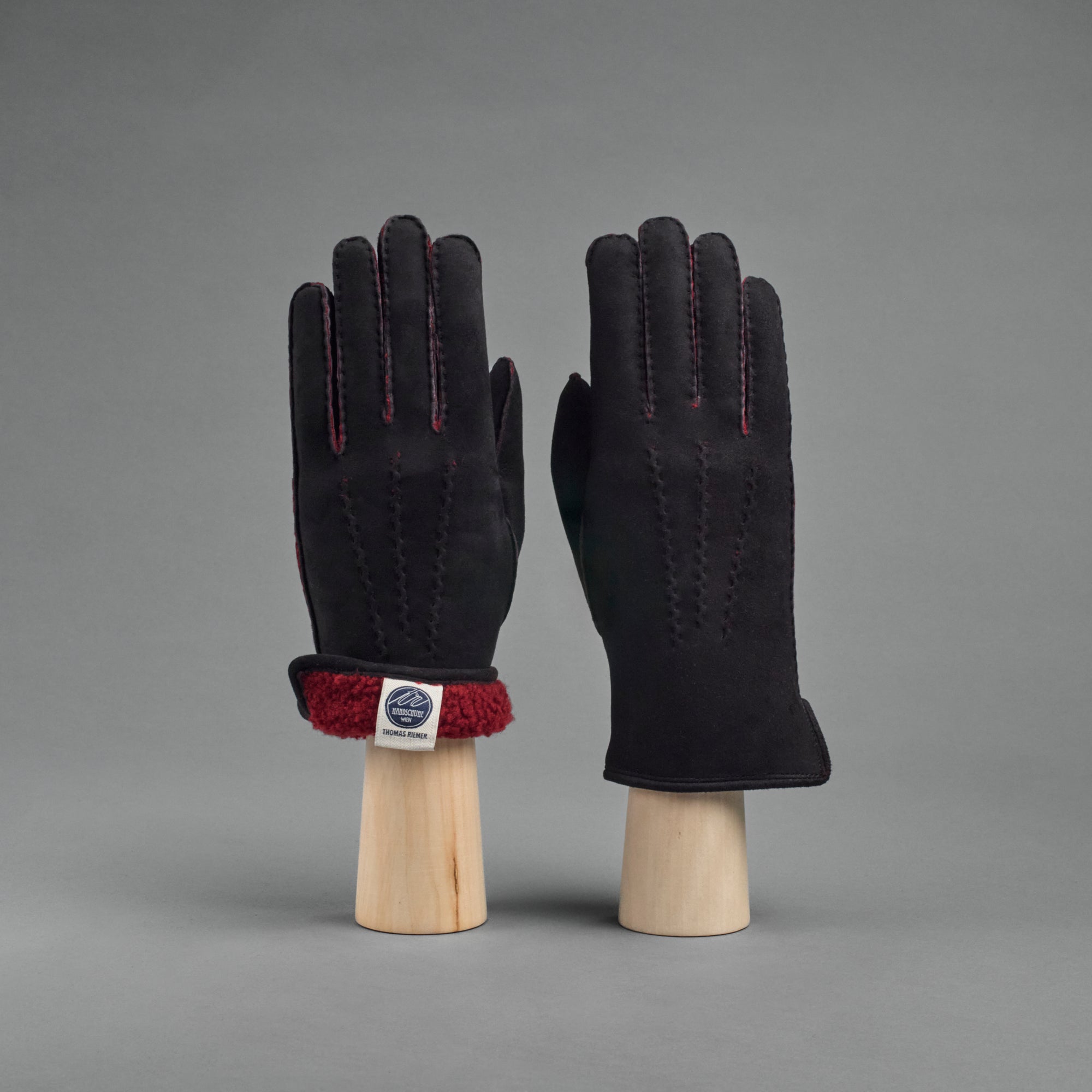 Damenhandschuhe aus schwarzem gelocktem Lammfell mit rotem Futter